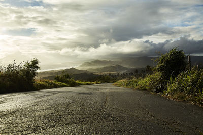 Road amidst trees against sky