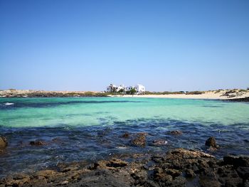 Scenic view of sea against clear blue sky