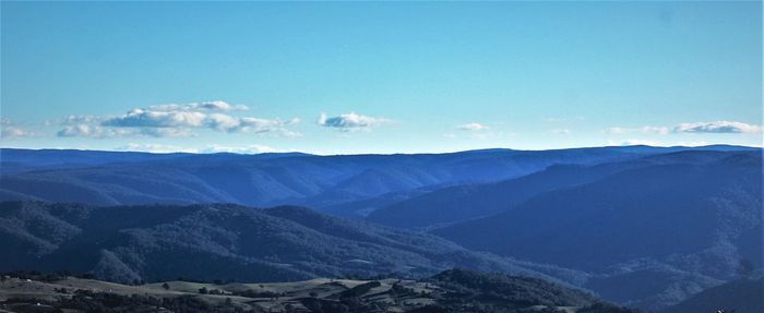 Scenic view of mountains against blue sky