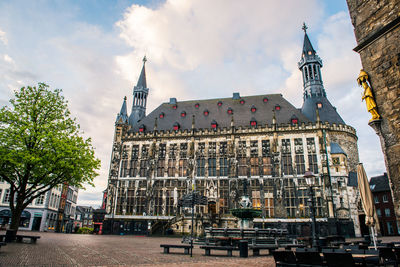 Low angle view of buildings against cloudy sky