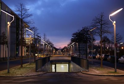 Illuminated bridge over canal in city at dusk