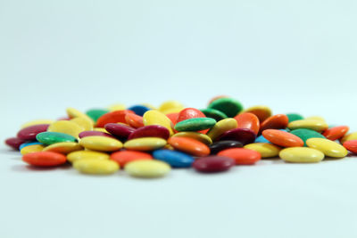 Close-up of multi colored candies against white background