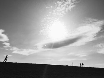 Silhouette people standing against sky