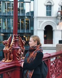 Woman looking away while standing by railing