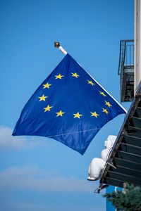 Low angle view of flags against clear blue sky