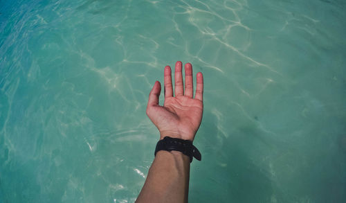 High angle view of person hand in swimming pool