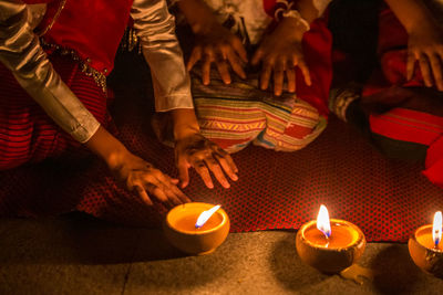 High angle view of people on lit candles