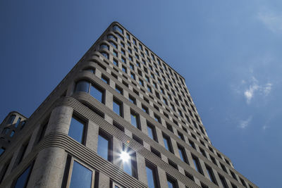 Low angle view of office building against blue sky