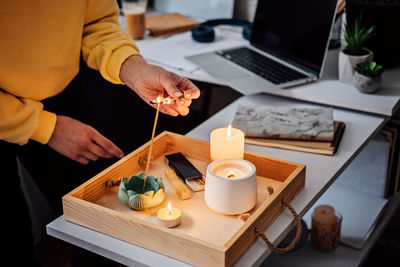 Meditation, relaxation after work. woman getting ready meditating and lights up indian incense