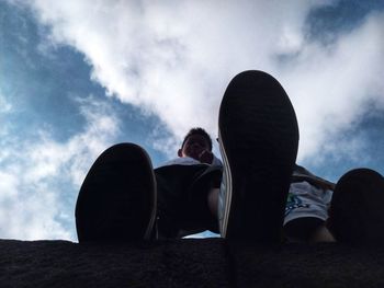 Rear view of man sitting on book against sky