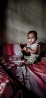 Portrait of cute boy on bed at home