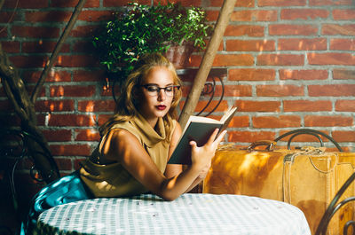 Young woman using mobile phone while sitting on chair