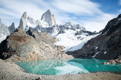 Scenic view of snowcapped mountains and lake against cloudy sky in los glaciares national park