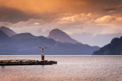 Rear view of a woman overlooking calm lake