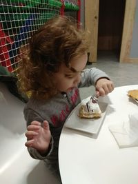 Boy playing with food on table