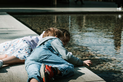 Rear view of siblings in water