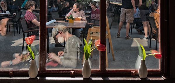 People at sidewalk cafe seen through glass window