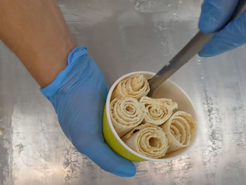 Midsection of person holding ice cream on table