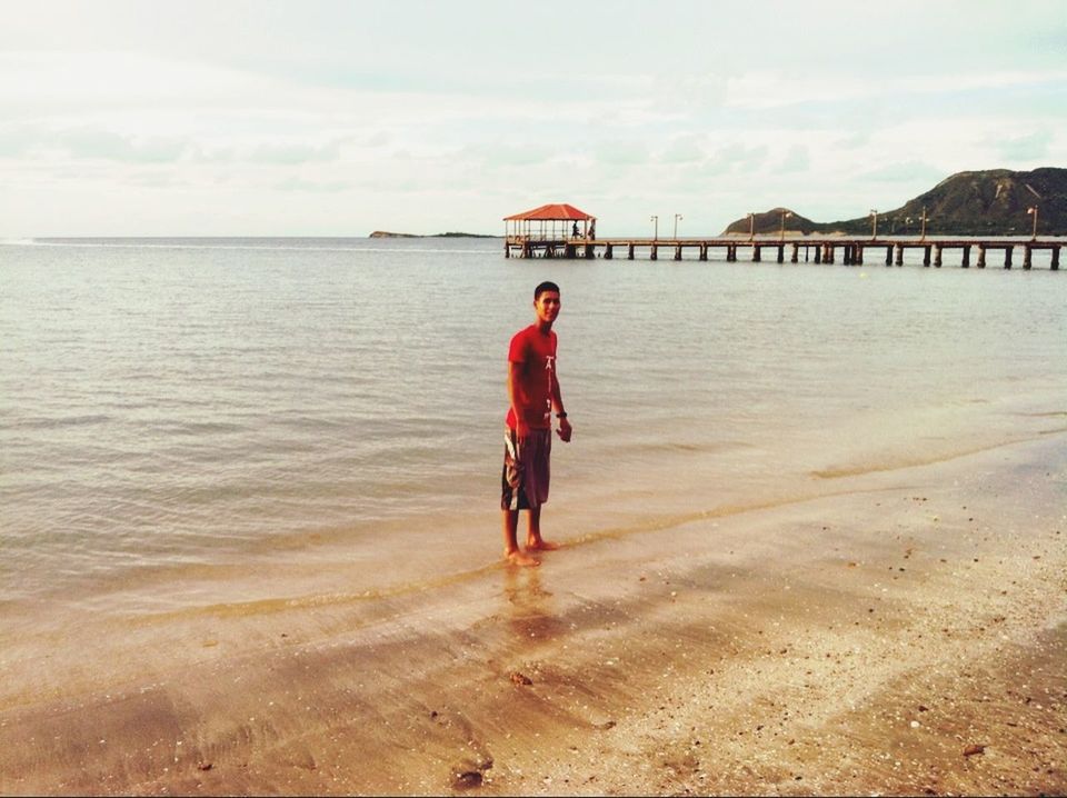 water, beach, sea, full length, shore, lifestyles, sand, sky, leisure activity, casual clothing, horizon over water, standing, person, vacations, rear view, tranquility, tranquil scene, scenics