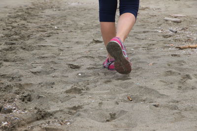 Low section of woman walking on beach