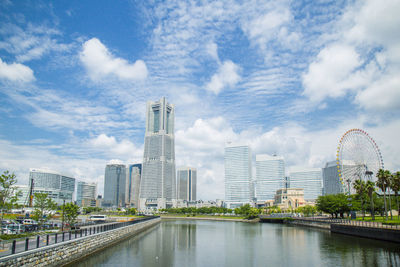 Buildings in city against cloudy sky