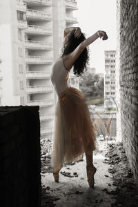 Full length of ballet dancer in abandoned building