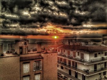 Buildings against cloudy sky at sunset