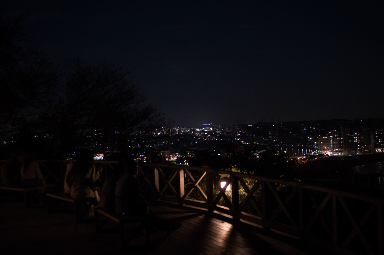 ILLUMINATED BRIDGE IN CITY AT NIGHT