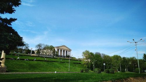 Built structure on field by trees against sky