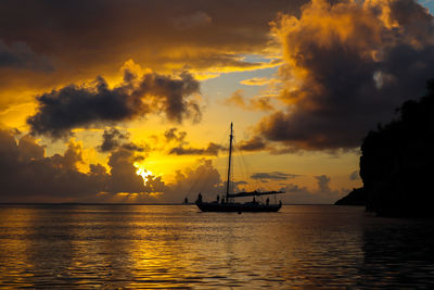 Silhouette sailboat in sea against sky during sunset