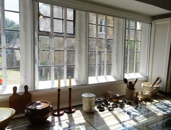 Utensils with candlestick holders on kitchen counter by window