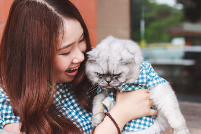 Full length of woman with cat with eyes closed