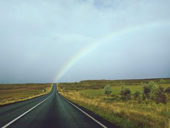 Scenic view of rainbow over road against sky