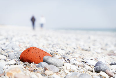 Close-up of pebbles on beach against clear sky