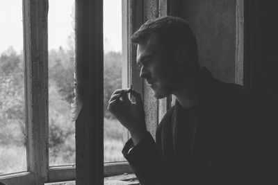 Portrait of young man smoking cigarette