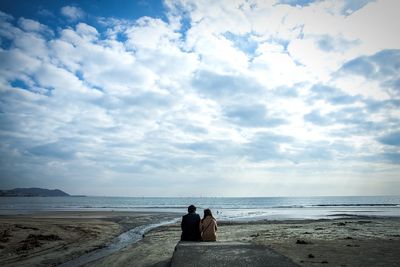 Scenic view of beach against cloudy sky