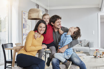 Portrait of happy family with two kids at home