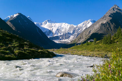 Scenic view of snowcapped mountains against clear blue sky