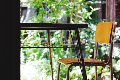 Close-up of empty chairs and table against window