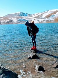 Full length of teenage boy standing in lake during winter