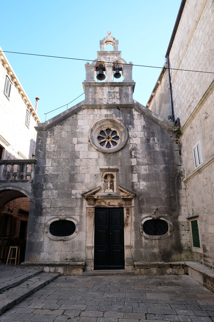 LOW ANGLE VIEW OF CROSS AGAINST BUILDING