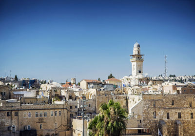 Buildings in town against clear blue sky