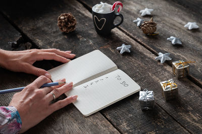 High angle view of person reading book on table