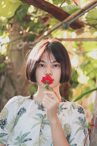 Portrait of young woman and rose flower