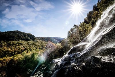 Scenic view of waterfall against sky