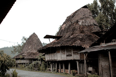 Old houses in village against clear sky