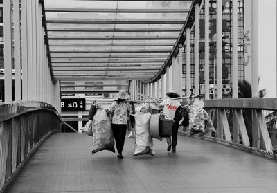 Rear view of people walking in corridor of building