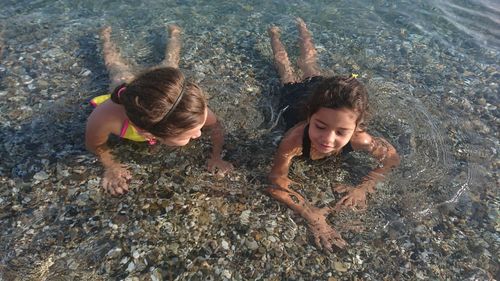 High angle view of siblings on shore at beach