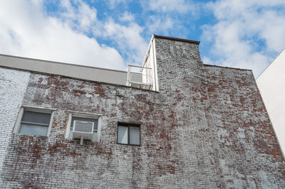 Low angle view of building against cloudy sky