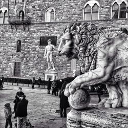 Statue of woman in front of building